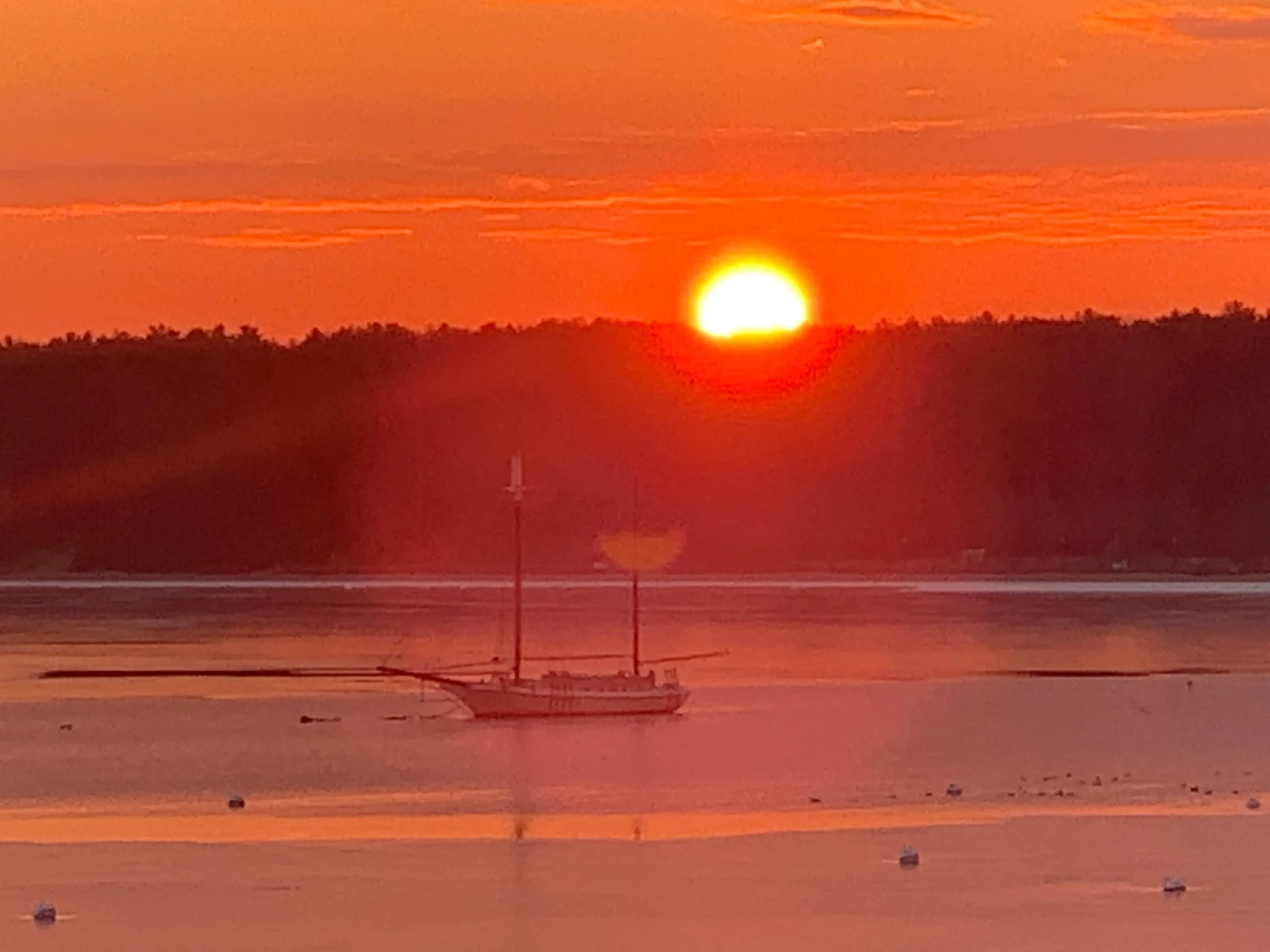 Sailboat silhouette against orange sunset